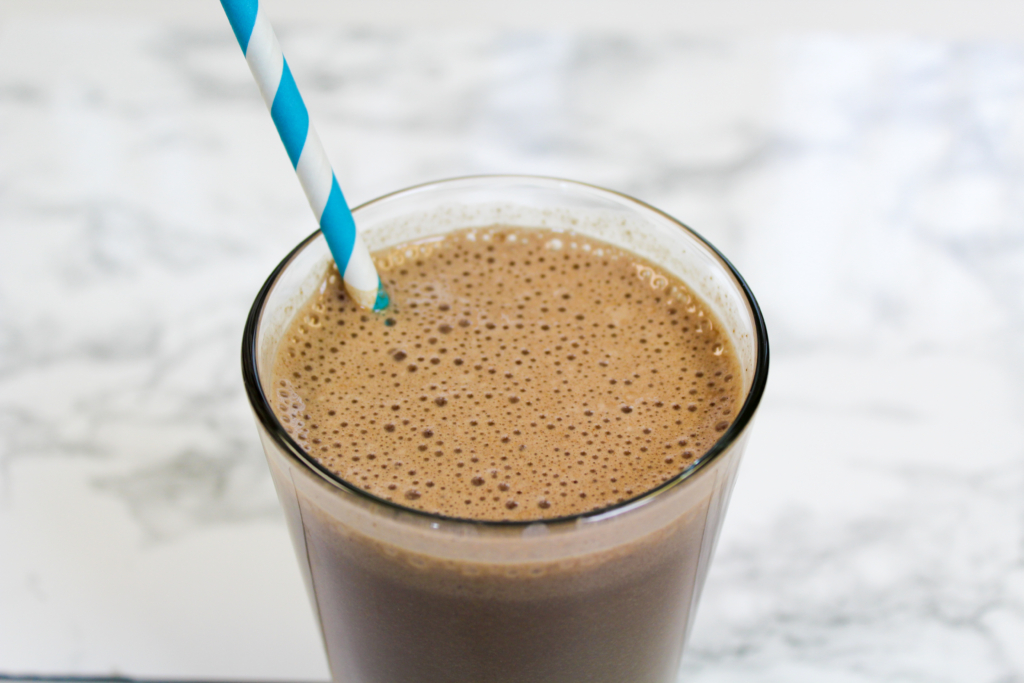 Mocha smoothie in a glass with a straw.