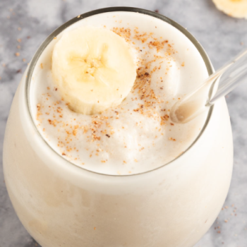 Banana licuado in a glass topped with banana and cinnamon.