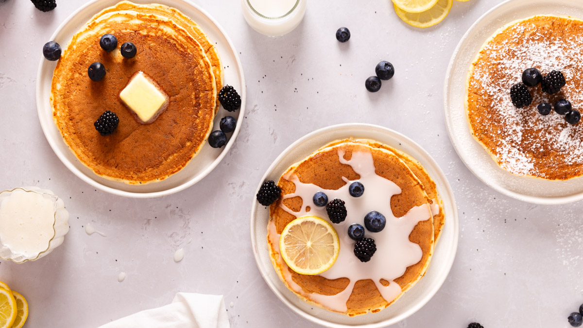 Image of lemon poppyseed pancakes on plates with icing and berries