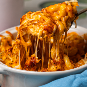 Image of someone scooping an extra cheesy spoonful of mac and cheese.