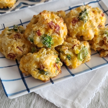 Image of cheesy veggie pepperoni bites stacked on a plate.