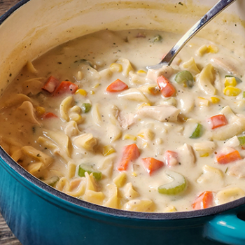 Image of creamy chicken noodle soup in a pot.