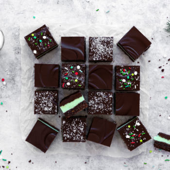 Image of Creme de Menthe bars surrounded by a glass of milk and festive holiday decorations.