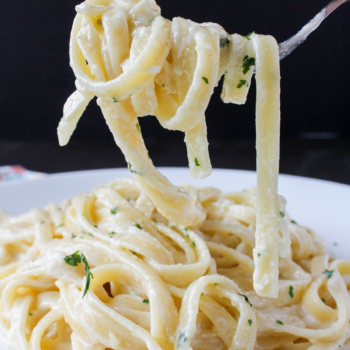 Image of a fettuccine Alfredo noodles twirled around a fork.