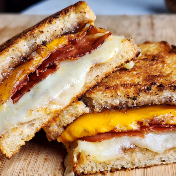 Image of a halved fig and prosciutto grilled cheese sandwich.