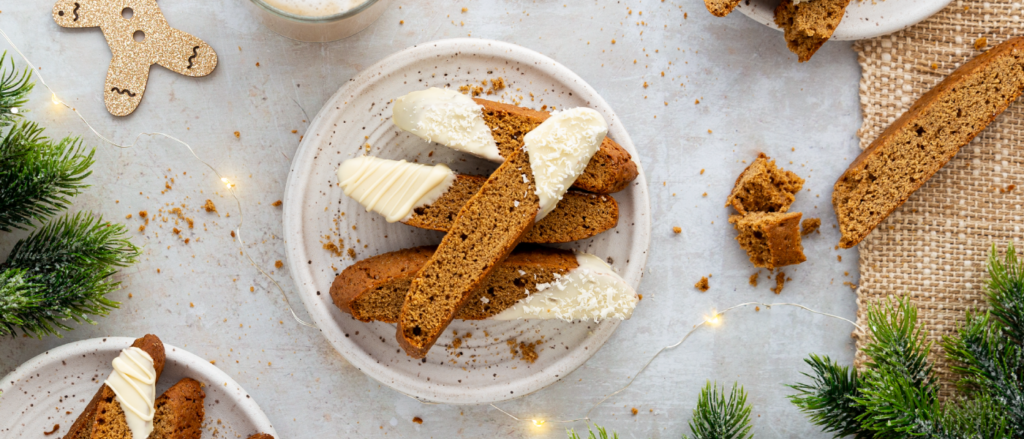 Image of gingerbread biscottis stacked on a plate.