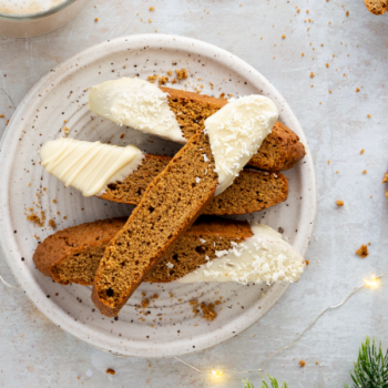 Image of gingerbread biscottis stacked on a plate.