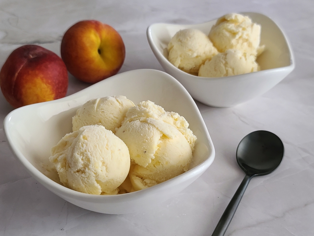 Image of two bowls of fresh peach ice cream.