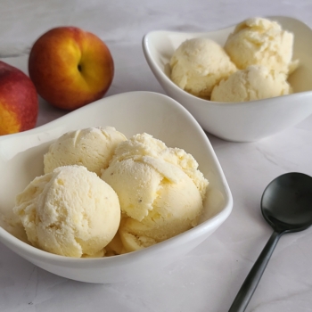 Image of two bowls of fresh peach ice cream.