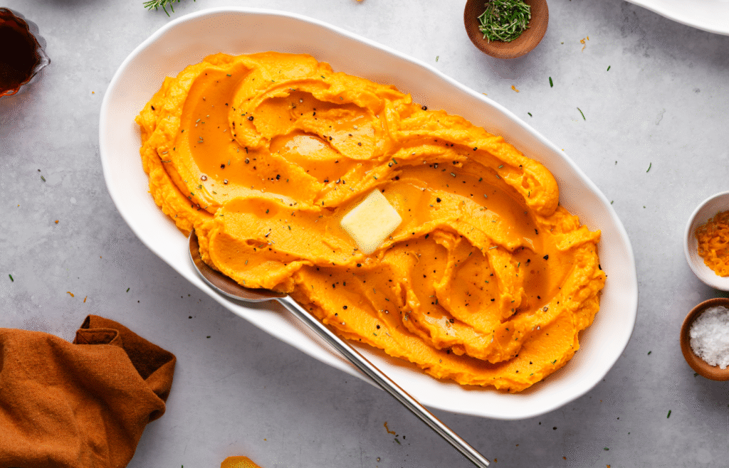 Image of a serving dish filled with mashed maple-whipped sweet potatoes.