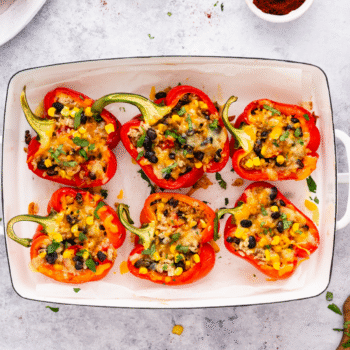 Overhead image of vegetarian stuffed peppers in a baking dish.